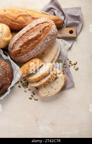 Assortimento di vari tipi di delizioso pane appena sfornato su sfondo bianco, vista dall'alto. Foto Stock