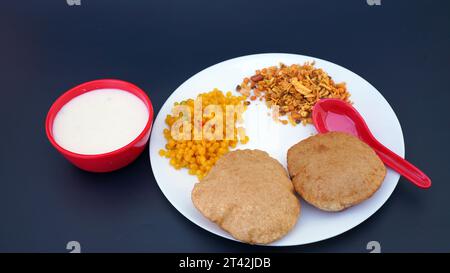 Cibo indiano - puri Bhaji e kheer. Ricetta piccante di patate semi secche dell'India settentrionale nota anche come Batata o Aloo ki Sabji, curry di patate o dum alu curry Foto Stock