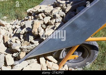 ha versato rifiuti edili da una carriola da vicino, ha rimosso la pietra da costruzione Foto Stock