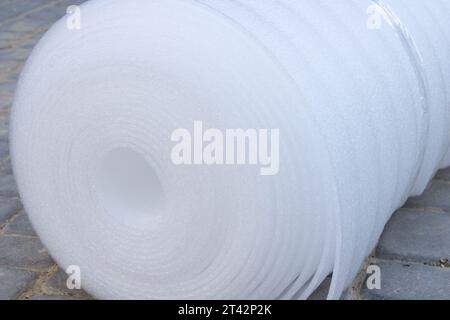 Primo piano di un rivestimento bianco sul pavimento in un rotolo di polietilene Foto Stock