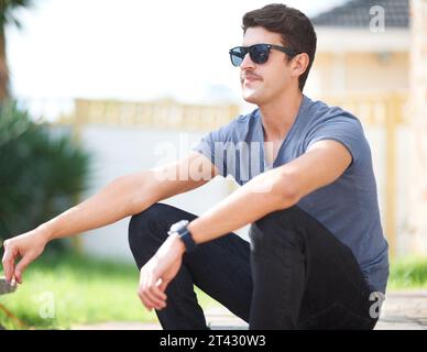 Uomo che indossa occhiali da sole, sigarette o pensa, rilassati all'aperto e alla moda nel cortile di casa o a casa. Fumare, persona fresca in occhiali o. Foto Stock