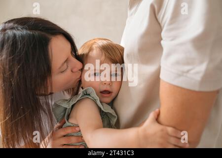 Ritratto di una giovane coppia che bacia la figlia Foto Stock