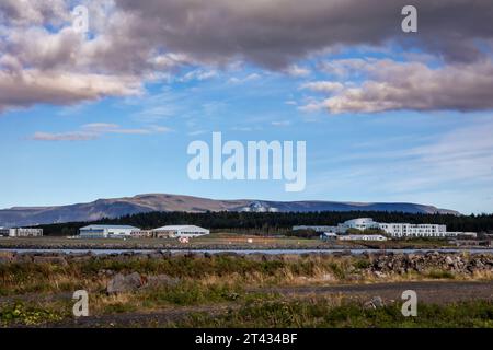 Reykjavik, Islanda - 25 settembre 2023: Paesaggio con aeroporto nazionale di Reykjavik e edificio Perlan, montagne sullo sfondo. Foto Stock