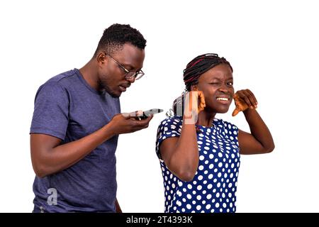 ritratto di un giovane geloso che controlla i messaggi sul cellulare della sua ragazza. Foto Stock