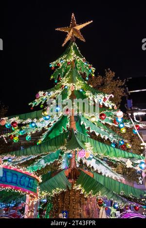 La magica attrazione sull'albero di Natale di Perpignan, uno spettacolo abbagliante di luci festive che illuminano la notte, che emettono un caldo bagliore in città. Foto Stock