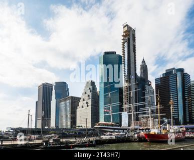 Skyline di Lower Manhattan, visto dal Molo 17 presso South St., Seaport, con una storica nave a vela in primo piano, 2023, New York City, USA Foto Stock