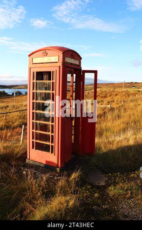 Una cabina telefonica rossa intemprata situata in una posizione isolata a lato della strada sull'isola di Lewis, Ebridi esterne, Scozia, Regno Unito. Foto Stock