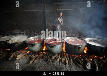 Gli uomini palestinesi preparano il cibo in grandi pentole bollenti su fuochi di legno a causa della mancanza di gas di cottura, che sarà distribuito alle famiglie sfollate in seguito alla richiesta di Israele di più di un milione di residenti nella parte settentrionale di Gaza di trasferirsi a sud, a Rafah, nella striscia meridionale di Gaza sabato 28 ottobre 2023. Lo sciopero israeliano continua a Gaza in mezzo alla carenza di forniture mediche, acqua e spegnimento, ma gli attacchi aerei israeliani hanno causato danni sostanziali alle infrastrutture sul lato palestinese. Foto di Ismael Mohamad/UPI. Foto Stock