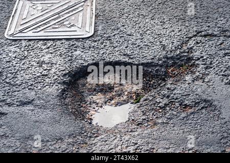 Dorney, Buckinghamshire, Regno Unito. 27 ottobre 2023. Una delle molte buche della strada nel Dorney Village, Buckinghamshire, in attesa di essere riparata dal Consiglio del Buckinghamshire. Molte delle strade del Buckinghamshire sono ancora in cattivo stato di riparazione. Credito: Maureen McLean/Alamy Foto Stock