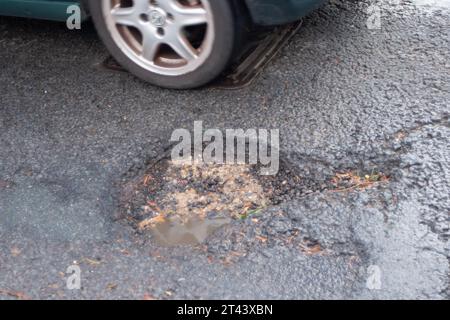 Dorney, Buckinghamshire, Regno Unito. 27 ottobre 2023. Una delle molte buche della strada nel Dorney Village, Buckinghamshire, in attesa di essere riparata dal Consiglio del Buckinghamshire. Molte delle strade del Buckinghamshire sono ancora in cattivo stato di riparazione. Credito: Maureen McLean/Alamy Foto Stock