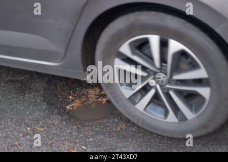 Dorney, Buckinghamshire, Regno Unito. 27 ottobre 2023. Una delle molte buche della strada nel Dorney Village, Buckinghamshire, in attesa di essere riparata dal Consiglio del Buckinghamshire. Molte delle strade del Buckinghamshire sono ancora in cattivo stato di riparazione. Credito: Maureen McLean/Alamy Foto Stock