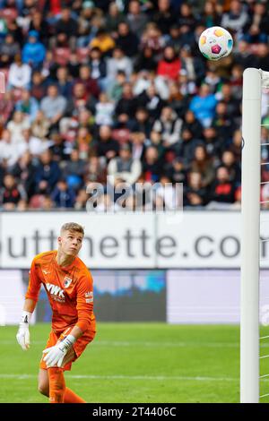 28 ottobre 2023, Baviera, Augusta: Calcio, Bundesliga, FC Augsburg - VfL Wolfsburg, Matchday 9, WWK Arena. Il portiere di Augusta Finn Dahmen guarda la palla colpire la traversa. Foto: Daniel Löb/dpa - NOTA IMPORTANTE: In conformità ai requisiti della DFL Deutsche Fußball Liga e del DFB Deutscher Fußball-Bund, è vietato utilizzare o far utilizzare fotografie scattate nello stadio e/o della partita sotto forma di immagini di sequenza e/o serie di foto simili a video. Foto Stock