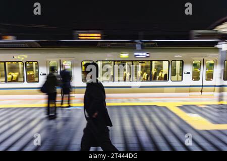 Immagini con la sfocatura intenzionale del movimento di un treno di notte in una stazione ferroviaria in Giappone Foto Stock