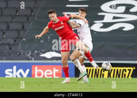 Jake Young di Swindon Town è sfidato da Milton Keynes Dons Daniel Harvie durante la seconda metà della partita Sky Bet League 2 tra MK Dons e Swindon Town allo stadio MK, Milton Keynes sabato 28 ottobre 2023. (Foto: John Cripps | mi News) crediti: MI News & Sport /Alamy Live News Foto Stock