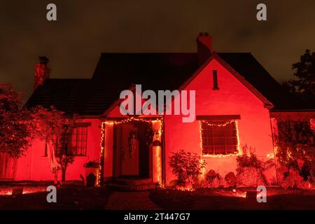 Casa di Halloween illuminata in rosso con il cielo notturno minaccioso Foto Stock