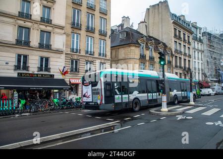 Un autobus cittadino articolato percorre le strade di Parigi, in Francia, come parte del sistema di transito urbano. Foto Stock