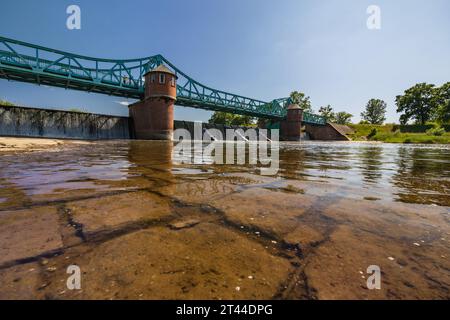 Breslavia, Polonia - 4 giugno 2023: Lungo ponte Bartoszowicki pieno di turisti a piedi e ciclisti sul livello dell'acqua visto dalla parte secca del fiume al sole Foto Stock