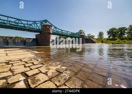 Breslavia, Polonia - 4 giugno 2023: Lungo ponte Bartoszowicki pieno di turisti a piedi e ciclisti sul livello dell'acqua visto dalla parte secca del fiume al sole Foto Stock