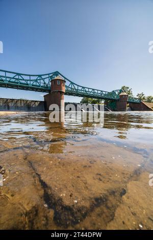 Breslavia, Polonia - 4 giugno 2023: Lungo ponte Bartoszowicki pieno di turisti a piedi e ciclisti sul livello dell'acqua visto dalla parte secca del fiume al sole Foto Stock