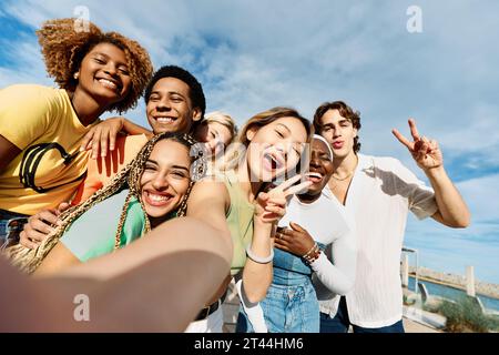 Donna cinese che fa un selfie con amici multietnici Foto Stock