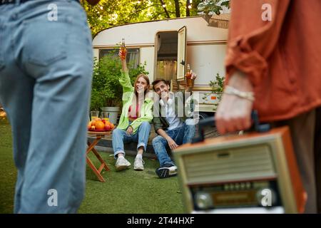 Giovani felici che si divertono al picnic durante l'estate, incontrando amici Foto Stock