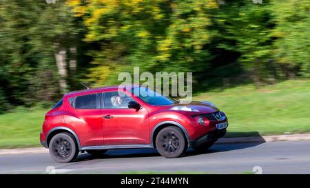 Milton Keynes, Regno Unito - 28 ottobre 2023: 2011 auto Nissan Juke rossa che guida su una strada inglese Foto Stock