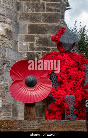 grande papavero rosso davanti a piccole corone appese a un modello o a una scultura di un soldato nella chiesa di lymington per commemorare l'armistizio della domenica Foto Stock