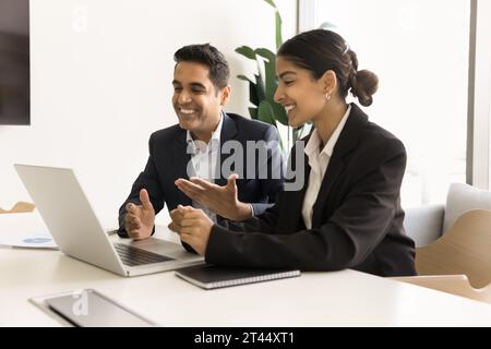 Un paio di felici colleghi d'affari indiani che parlano in videochiamata Foto Stock