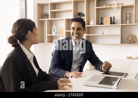 Un manager e un cliente allegri che discutono di una collaborazione di successo al laptop Foto Stock