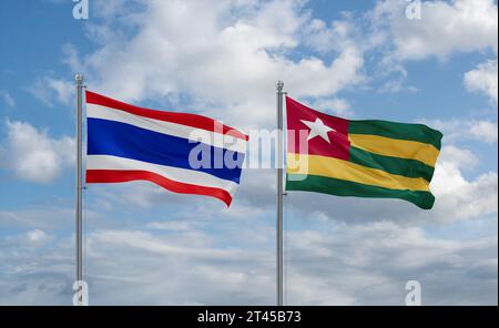 Togo, Repubblica del Togo e Thailandia bandiere che sventolano insieme nel vento su un cielo blu nuvoloso, concetto di relazione tra due paesi Foto Stock