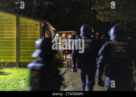 Gelsenkirchen, Germania. 28 ottobre 2023. Gli agenti di polizia si trovano di fronte alla clubhouse di un giardino d'assegnazione. La polizia ha posto fine a un evento di sospetti sostenitori della scena di destra a Gelsenkirchen. Secondo i primi risultati della polizia, circa 80 persone si erano riunite il sabato sera in un circolo di un giardino per un concerto. Credito: Christoph Reichwein/dpa/Alamy Live News Foto Stock