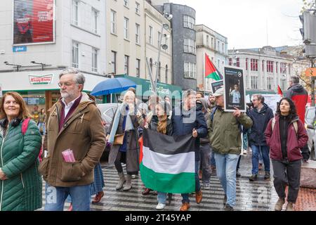 Cork, Irlanda. 28 ottobre 2023. DC 28-10-23 persone di Cork in piedi in solidarietà con la Palestina nonostante la forte pioggia, Cork, Irlanda. In mezzo alle forti piogge, Cork City oggi ha assistito a una clamorosa manifestazione di solidarietà per il popolo palestinese. Riprendendo il sostegno di lunga data dell'Irlanda alla causa palestinese, voci appassionate risuonano per le strade, incarnando un legame storico di empatia e unità. Nonostante il tempo, lo spirito della protesta rimane resiliente con un appello collettivo alla giustizia e alla pace. Crediti: Damian Coleman/Alamy Live News Foto Stock