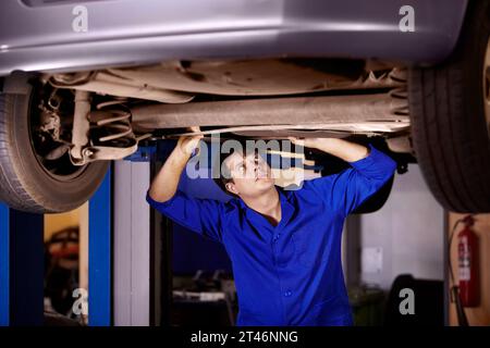 Auto, ispezione o riparazione con un meccanico in un garage per una relazione su un servizio di assistenza del veicolo per l'assicurazione. Manutenzione, professionale e giovane Foto Stock