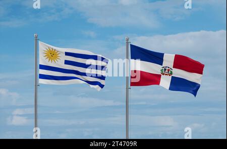 Repubblica Dominicana e Uruguay bandiere che sventolano insieme sul cielo nuvoloso blu, concetto di due relazioni tra paesi Foto Stock