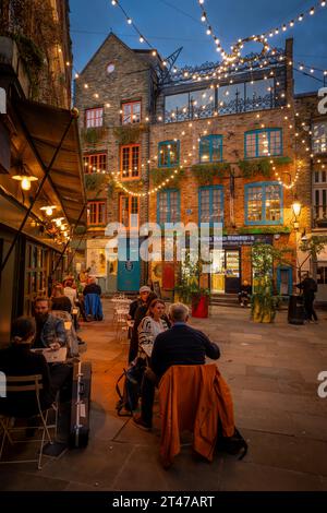 Londra, Regno Unito: Neal's Yard nell'area di Covent Garden nel centro di Londra. Persone sedute fuori da un ristorante la sera. Foto Stock