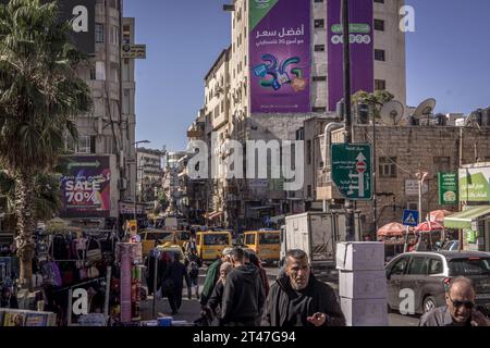 La strada, il traffico, gli edifici e il popolo palestinese nel centro di Ramallah, la capitale dell'autonomia palestinese (Palestina) in Cisgiordania. Foto Stock