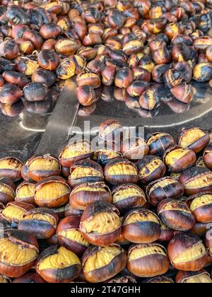 castagne, un mucchio di castagne arrostite con attenzione selettiva alla stalla. Cibo di strada tradizionale locale in Turchia, Italia ed Europa. strada deliziosa Foto Stock