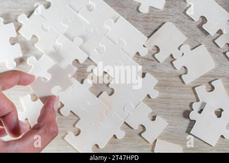 Mano che regge un pezzo di puzzle vuoto Foto Stock