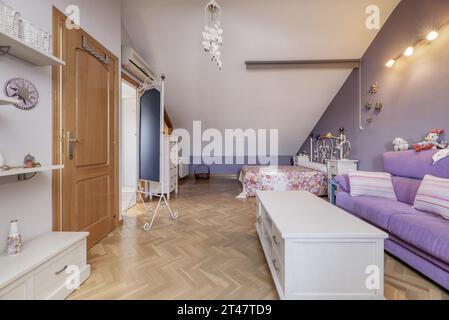 Camera con pareti dipinte di bianco e viola, pavimenti in parquet di quercia francese, mobili in legno bianco Foto Stock