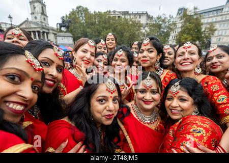 Londra, Regno Unito. 29 ottobre 2023. I ballerini tradizionali si riuniscono per i media dopo essersi esibiti sotto la pioggia a Diwali in Trafalgar Square, un evento sostenuto dal sindaco di Londra. La celebrazione annuale del Festival delle luci è celebrata da indù, sikh e gialli. Crediti: Stephen Chung / Alamy Live News Foto Stock