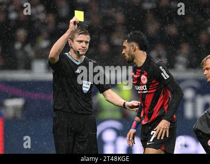 29 ottobre 2023, Assia, Francoforte sul meno: Calcio, Bundesliga, Eintracht Francoforte - Borussia Dortmund, Matchday 9, presso Deutsche Bank Park. L'arbitro Robert Schröder (l) mostra il cartellino giallo all'Omar Marmoush di Francoforte. Foto: Arne Dedert/dpa - NOTA IMPORTANTE: In conformità ai requisiti della DFL Deutsche Fußball Liga e del DFB Deutscher Fußball-Bund, è vietato utilizzare o far utilizzare fotografie scattate nello stadio e/o della partita sotto forma di immagini di sequenza e/o serie di foto simili a video. Foto Stock