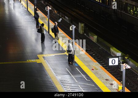 Kyoto, Giappone - 14 aprile 2023: In attesa di passeggeri non identificati al binario della stazione di Kyoto. La stazione di Kyoto ha la seconda stazione più grande del Giappone Foto Stock