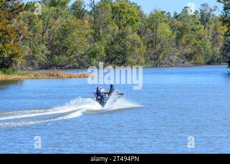 LAKE FAUSSE POINTE STATE PARK, LOUISIANA, USA - 25 OTTOBRE 2023: Vista posteriore di un uomo e una donna in motoscafo sul canale del bacino del fiume Atchafalaya Foto Stock