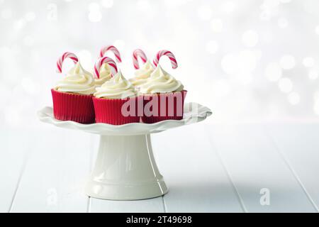 Cupcake natalizi decorati con glassa bianca e canne di caramelle natalizie Foto Stock