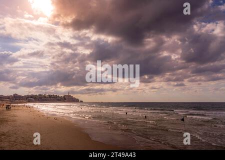 Il bellissimo tramonto sulla spiaggia di Tel Aviv, sulla spiaggia Charles Clore, con il mare Mediterraneo e la città vecchia di Jaffa in Israele, in una giornata nuvolosa. Foto Stock