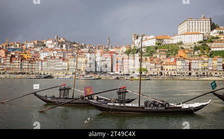 Barche storiche rabelo con barili portuali ormeggiate di fronte al quartiere di Ribiera sul fiume Douro, Gaia, Porto, Portogallo il 18 ottobre 2 Foto Stock