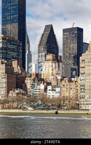 La Beekman Tower, 3 Mitchell Place, di colore dorato, si distingue tra i suoi vicini più oscuri del Midtown East di Manhattan. Vista da Roosevelt Island. Foto Stock