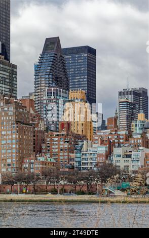 La Beekman Tower, 3 Mitchell Place, di colore dorato, si distingue tra i suoi vicini più oscuri del Midtown East di Manhattan. Vista da Roosevelt Island. Foto Stock