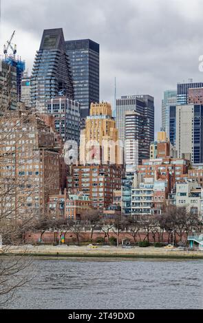 La Beekman Tower, 3 Mitchell Place, di colore dorato, si distingue tra i suoi vicini più oscuri del Midtown East di Manhattan. Vista da Roosevelt Island. Foto Stock