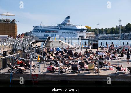 Gruppi di persone prendono il sole e prendono il sole presso la piscina marina di Allas in estate nel centro di Helsinki, Finlandia. Foto: Rob Watkins Foto Stock